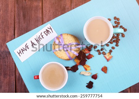 Two cups of coffee on the table. Coffee with milk on the table. Morning coffee for two. Cookies, rose petals, coffee beans and a cup on the table. Top view. Have a nice day. Cheerful romantic morning.