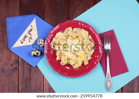 Egg pasta with quail egg, watercress salad and seeds. Dish pasta and coleslaw on the table. Delicious hearty lunch. Surprise for dear person. Top view. Pasta dish. Love letter, Declaration of love.