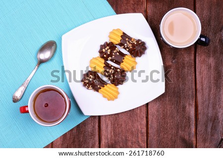 Cup of tea and coffee on the table. Cup of black tea and coffee with milk. Two cups on the table. A plate of cookies on the table. Snack for two.