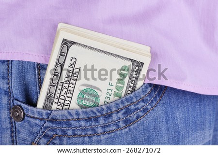 Dollars in the pocket of jeans. Bundle of dollars. Money in the pocket of trousers. Business casual. Men\'s jeans, shirt and a wad of dollars in his pocket. Bribe in the pocket.