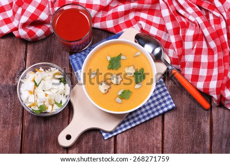 Cream soup of pumpkin and mushrooms. Diet. Delicious vegetable Breakfast. Food and beverage. A glass of tomato juice, a bowl of salad and a plate of pumpkin puree.