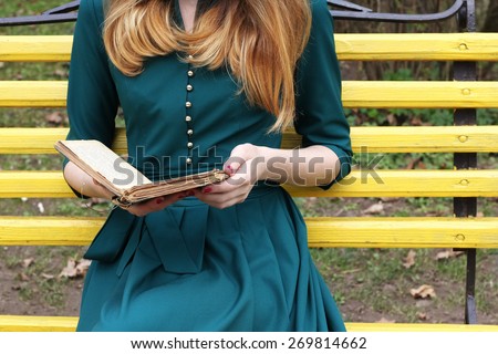 Girl in a romantic gown with a book in her hands. Pastime, recreation, relaxation, Hobbies, leisure. Reading books. Young woman on  the bench. Dreamer. The atmosphere of romance and tranquility.