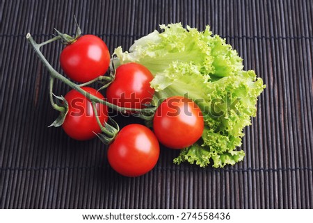 Vegetables on the table. Diet food. Dieting, weight lose. Organic vegetables. The cherry tomatoes on a branch. Red tomatoes on a branch, lettuce. Branch of ripe tomatoes. Fresh vegetables.