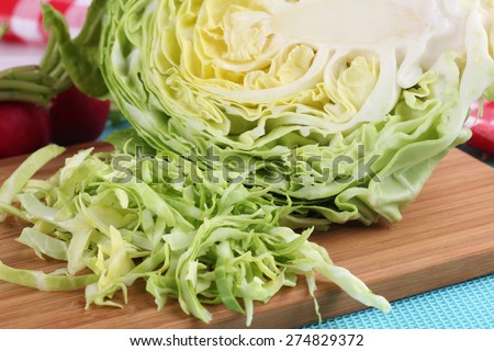 Sliced cabbage on the table. To cut a young cabbage. Green cabbage. To grow cabbage. To cook food. Fresh vegetables. Radish and cabbage. To prepare the salad. Cabbage soup diet. Benefits of cabbage.