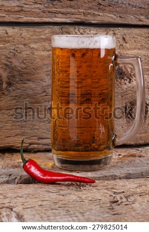 A glass of light beer and hot peppers on the table. In the pub. The interior of the pub. The effect of beer on the potency. The dangers of beer. Alcoholic drink, alcoholic. Symbol.