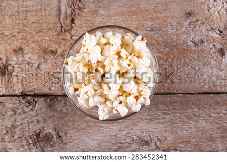 A bowl of popcorn on the table. Corn popcorn. Delicious movie snack. Mouth-watering classic appetizer. Corn is firing. A lot of popcorn on the table. Top view. Studio photography.