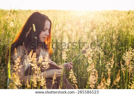 Beautiful girl in a field. Innocence, romance, embarrassment. Beautiful young woman in field. Romantic girl. The dreamer. Hipster girl. Hippie woman. Child of nature.