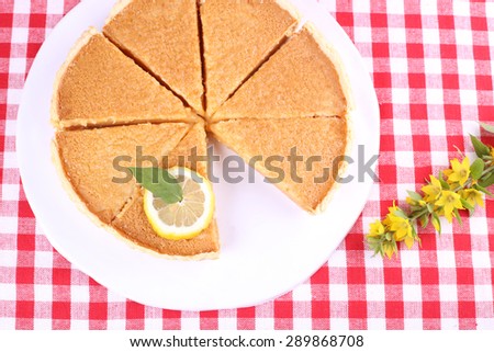 Round lemon cake, cut into slices. Delicious lemon cake. Pastries, patisserie, cafeteria. Pie and lemon. Dried lavender and pie on the table. Food, pastries.