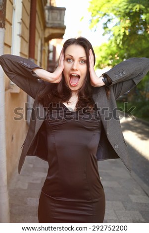 Beautiful surprised woman. Office worker. Office clerk in shock. The stress of the business world. Business fashion business style. Business woman on the street. Shock, surprise, stress.