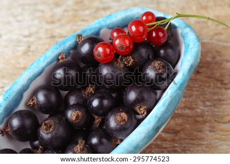 Berries in a bowl. Two kinds of blackcurrant. Red currant, black currant. Macro photo of berries. Close. Macro berries. Red and black berries. Gardening.