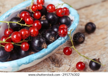 Berries in a bowl. Two kinds of blackcurrant. Red currant, black currant. Macro photo of berries. Close. Macro berries. Red and black berries. Still life