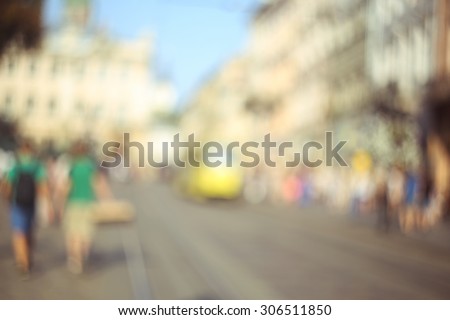 Street of the old town. Crowds of tourists on the street. Tram. Life in the city, a tourist town. Holidays in the city. Blurred background, bokeh. Open aperture.