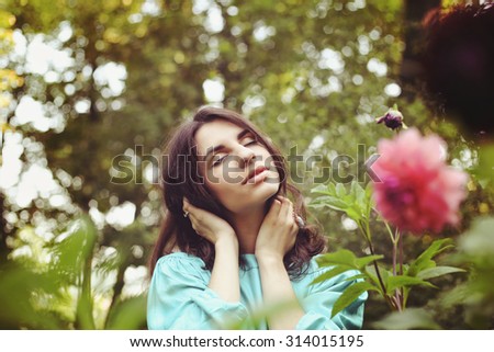 Beautiful girl with closed eyes. Girl and dahlias. Rest in the park. Enjoyment, relaxation and rest. Soulful girl. Young woman in the garden. Gardener. Grow flowers. Emotional portrait.