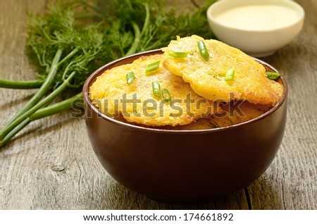 Potato pancakes in ceramic bowl on wooden table