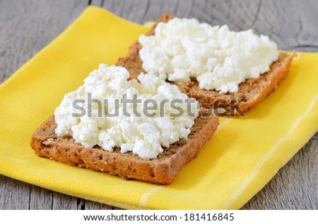 Bread with curd cheese on yellow kitchen napkin
