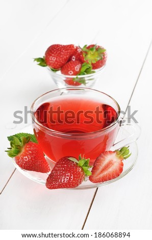 Strawberry tea and strawberries on white wooden table