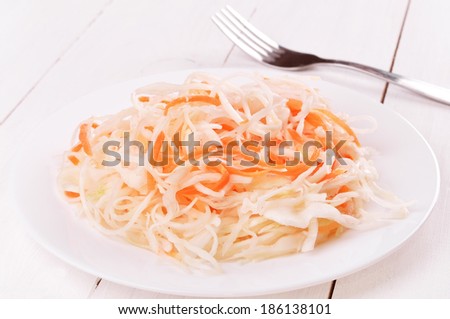 Sauerkraut on white plate on wooden table