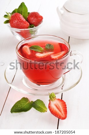 Strawberry tea and strawberries on white wooden table