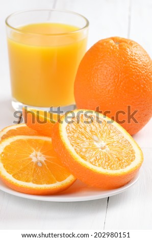 Oranges and orange juice on white wooden table