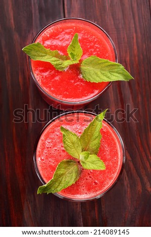 Watermelon cocktail with mint in glass on wooden table, top view