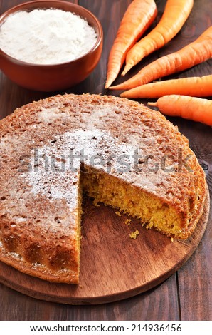 Carrot cake, flour and fresh carrot on wooden table