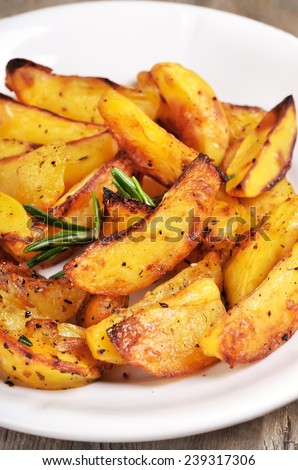 Fried potato wedges on white plate, close up view