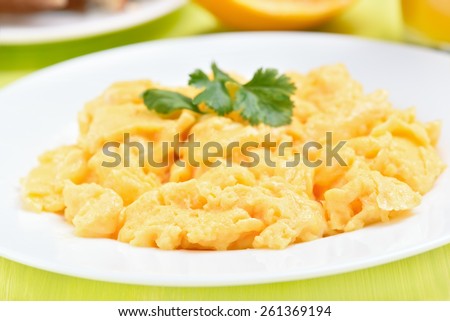 Scrambled eggs on white plate, close up view