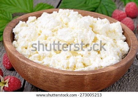 Fresh curd cheese in wooden bowl, close up view