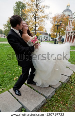 Handsome bride and funny groom kissing in the park