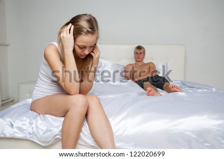 Woman upset, thinking and man lying on the bed