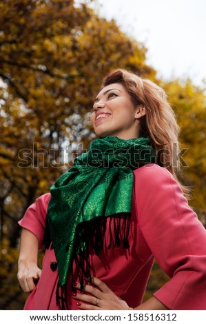 Beautiful woman in pink coat walks in the Park, autumn background
