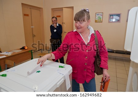 MOSCOW, RUSSIA - SEPTEMBER 8, 2013: Woman put election ballot with candidates for mayor of Moscow into the box on September 8, 2013 at the local election commission in Moscow.
