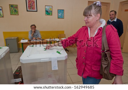 MOSCOW, RUSSIA - SEPTEMBER 8, 2013: Woman put election ballot with candidates for mayor of Moscow into the box on September 8, 2013 at the local election commission in Moscow.