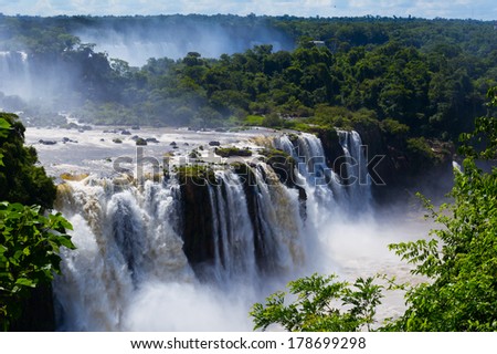 Iguazu Falls or Iguassu Falls in Brazil. Beautiful Cascade of waterfalls with clouds and jungle