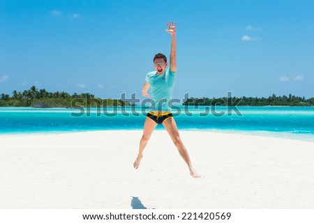 Man jump on beach with two islands on the background, happiness emotions, Maldives