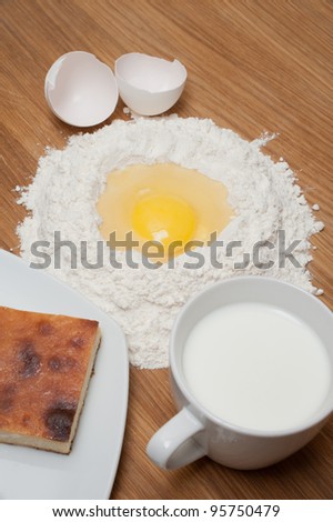 Cake with milk and flour with egg on the wood table
