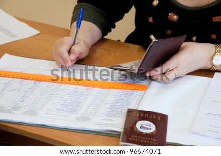 MOSCOW, RUSSIA - MARCH 4: Woman write name of voters in notebook on election of Russian President on March 4, 2012 at the local election commission in Moscow.