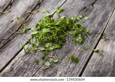 Organic watercress leaves on a rustic wooden board