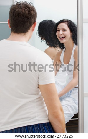 Woman laughing at guy in bathroom.