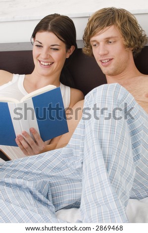 Couple reading a book in bed.