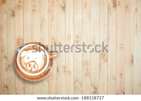 Coffee cup with cute pig pattern, top view on wood plank background