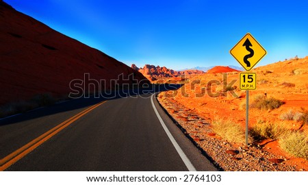 A desert road surrounded by mountains and boulders