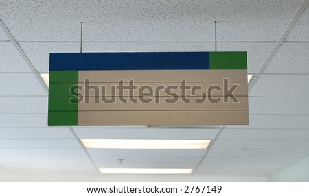 A blank sign hanging in a hallway of a school/office environment