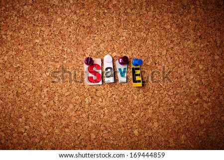Save - Cut out letters pinned on a cork notice board.