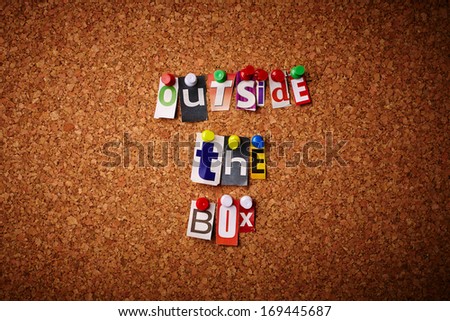 Outside the box - Cut out letters pinned on a cork notice board.