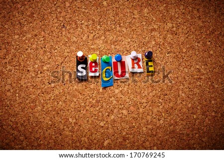Secure  - Cut out letters pinned on a notice board.