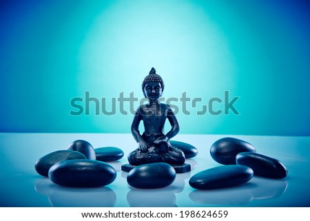 Buddah in a circle of hot stones Wellness and Spa Image, works perfect for advertising Health and Beauty, Spirituality or Massage.