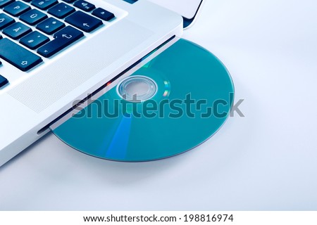 Portable Computer with Blu Ray Disc. Isolated on a blue background.