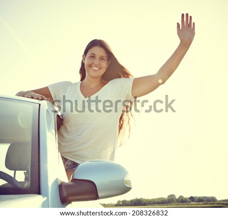 Hi - Young driver Woman Waving out of her new car, rental car.