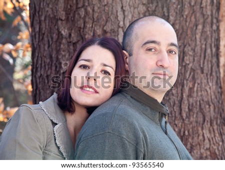Portrait of smiling husband and wife couple hugging and looking at the camera.